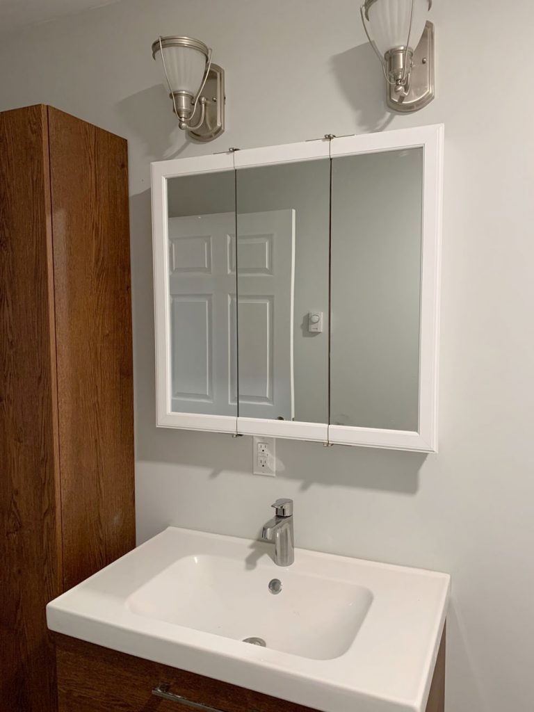 New bathroom vanity cabinet and sink in bathroom